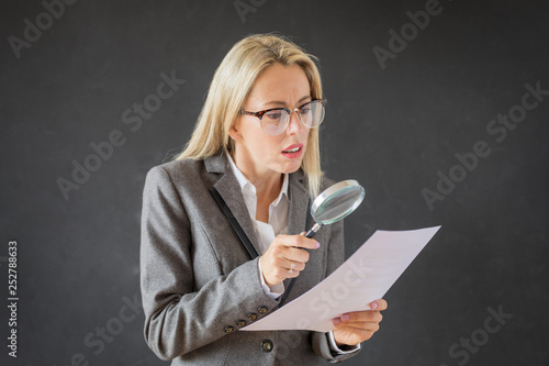 Woman carefully reading business contract with magnifying glass © Kaspars Grinvalds