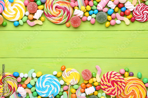 Sweet candies and lollipops on green wooden table © 5second