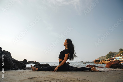 Young healthy woman practicing yoga on the beach at sunset © grthirteen