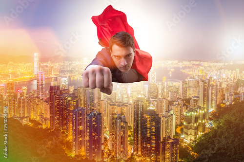 Superhero businessman flying over the city
