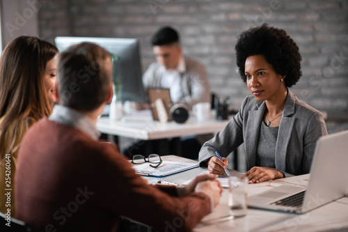 Couple going through investment plans with African American bank manager.