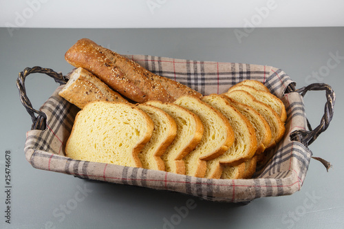 Pieces of french traditional baguette bread and brioche in a breadbasket for breakfast © oceane2508