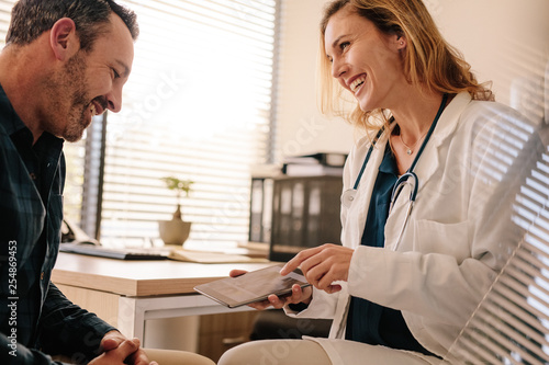 Female doctor showing good test results to a male patient