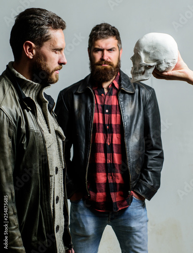 Looking deep into eyes of your fear. Man brutal bearded hipster looking at skull symbol of death. Overcome your fears. Be brave. Focused on breaking fear. Psychology concept. Human fears and courage