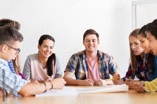 education, architecture and people concept - group of smiling students meeting at school © Syda Productions