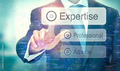 A business man selection a button on a futuristic display with a Expertise concept written on it.