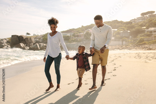 Family with son walking along the beach © Jacob Lund 