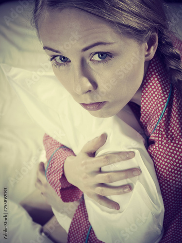 Sad depressed girl in bed gripping pillow © Voyagerix