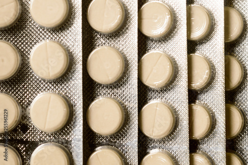 Heap of Capsules packed in blisters, round patterned shaped medicine tablet or antibiotic pills. Medical Pharmacy theme. Close up with copy space.