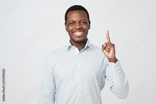 African young man showing index fingers up, giving advice