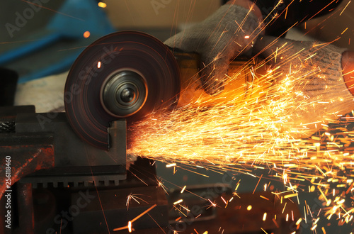 a gloved worker with a grinder cuts a carbide plate and this causes a lot of sparks © InWay