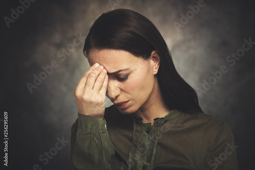 Young woman has headache on a grungy background © Minerva Studio