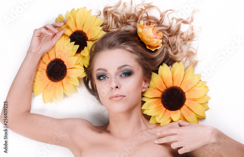 beautiful young woman lying among the flowers of a sunflower © yurolaitsalbert