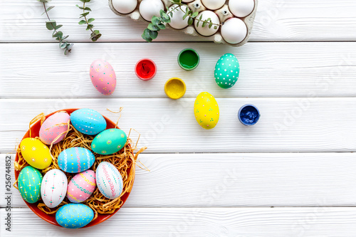 Colorful Easter eggs and paint for celebration on white background top view mock up © 9dreamstudio