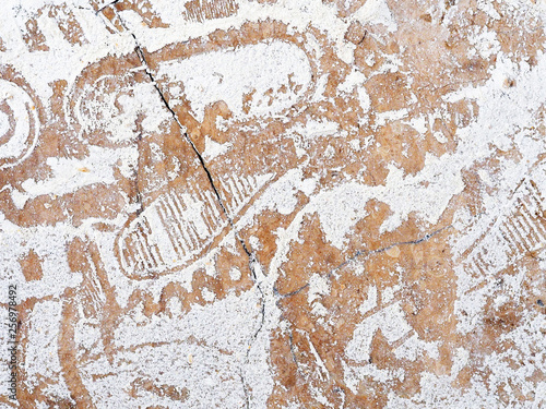 White powder scattered on the floor. Footprints, face and clothing imprint on white powder