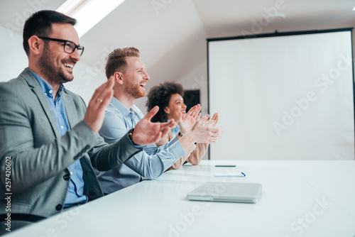 Business people applauding in office at presentation. © bnenin