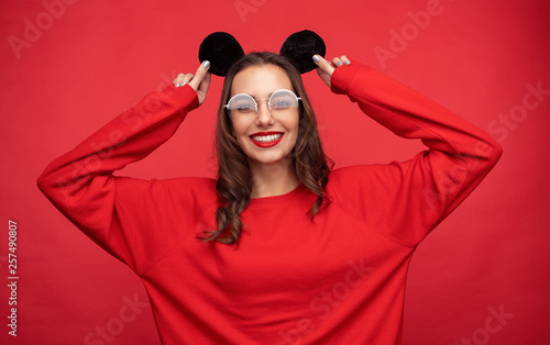 Smiling woman in red clothing wearing mouse ears © kegfire