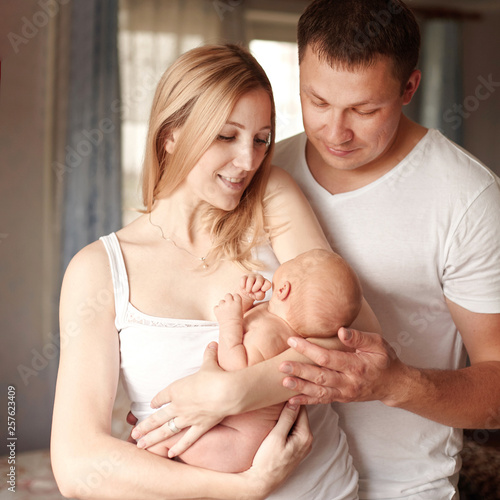 happy family with newborn baby standing in their apartment © yurolaitsalbert