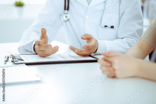 Doctor man and patient are discussing something, just hands at the table. Medicine and health care concepts © rogerphoto