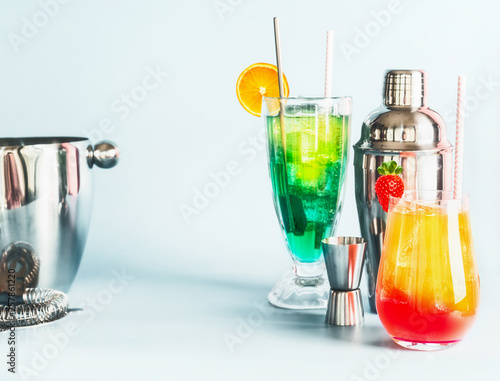 Various colorful long drinks and cocktails bar tools at light blue background, copy space. Summer alcoholic beverages © VICUSCHKA
