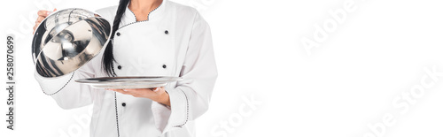 Panoramic shot of chef in uniform holding tray with cloche isolated on white © LIGHTFIELD STUDIOS