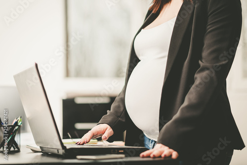 Pregnant woman working on laptop at office © thodonal