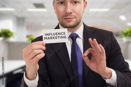 Business, technology, internet and networking concept. Young entrepreneur showing keyword: Influence marketing © Egor