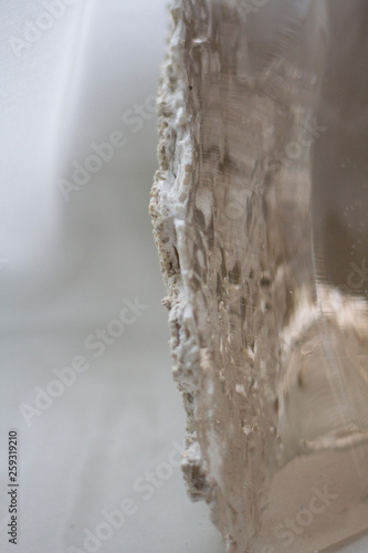 closeup of a large crystal of transparent quartz like water with a harder base vertical blurred background © Elen Spirit