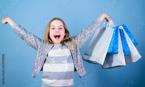 Seasonal sale. Fashion girl customer. Happy child in shop with bags. Shopping day happiness. Birthday girl shopping. Fashion boutique. Fashion trend. Fashion shop. Little girl with bunch packages © Roman Stetsyk