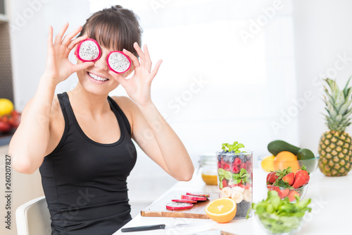 Happy young woman puts slices of dragon fruit as glasses. © REDPIXEL