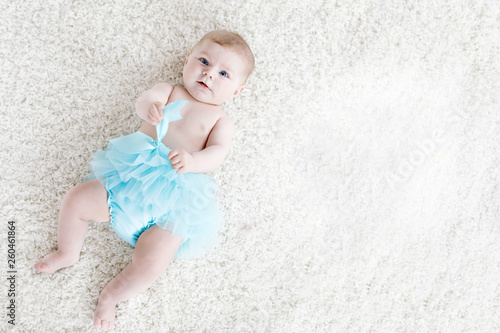 Adorable baby girl on white background wearing turquoise tutu skirt. Cute little child laughing and smiling. Happy carefree baby. Childhood, new life concept © Irina Schmidt