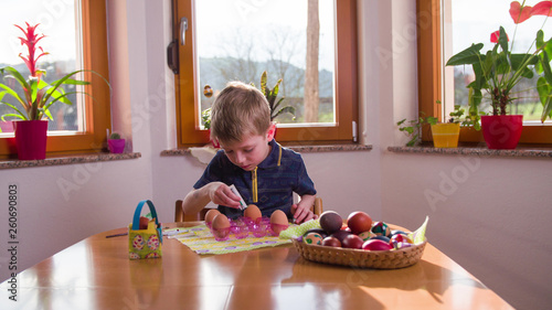 Child painting Easter eggs © Video_StockOrg