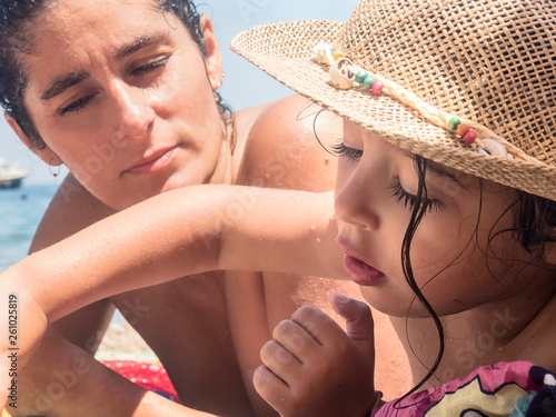 portrait of a kid with her mother on the beach © Raul Mellado
