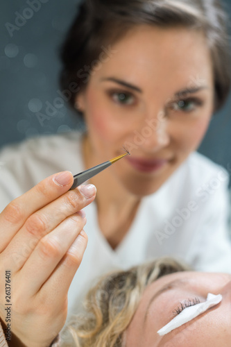 applying false eyelashes with tweezers © auremar