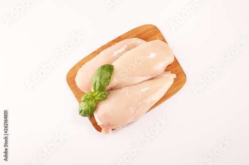 Raw chicken breasts and spices on wooden cutting board, close up © beats_