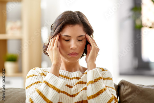people , health and stress concept - unhappy woman suffering from head ache at home © Syda Productions