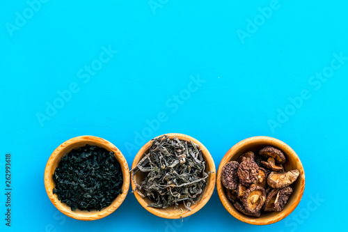 Chinese and Jupanese food cooking with mushrooms, spices, weeds in bowl on blue background top view copy space © 279photo