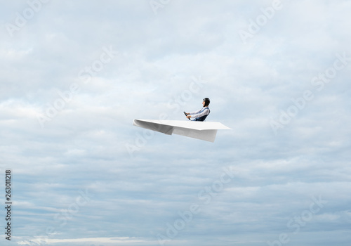 Businessman in aviator hat sitting in paper plane © adam121