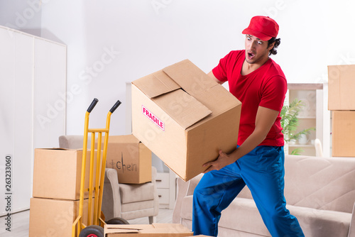 Young male contractor with boxes working indoors