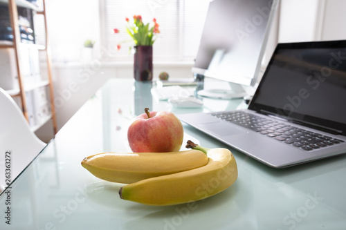 Banana, Apple And Laptop On Desk © Andrey Popov
