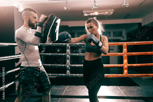 Strong muscular boxer Caucasian woman punching and having training in ring. © dusanpetkovic1